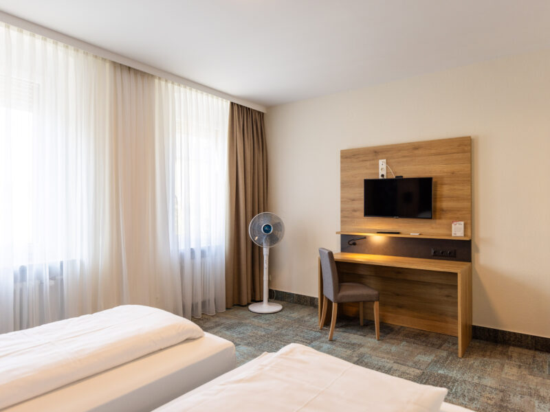 Modernes Doppel- oder Zweibettzimmer mit zwei Einzelbetten, TV und Schreibtisch