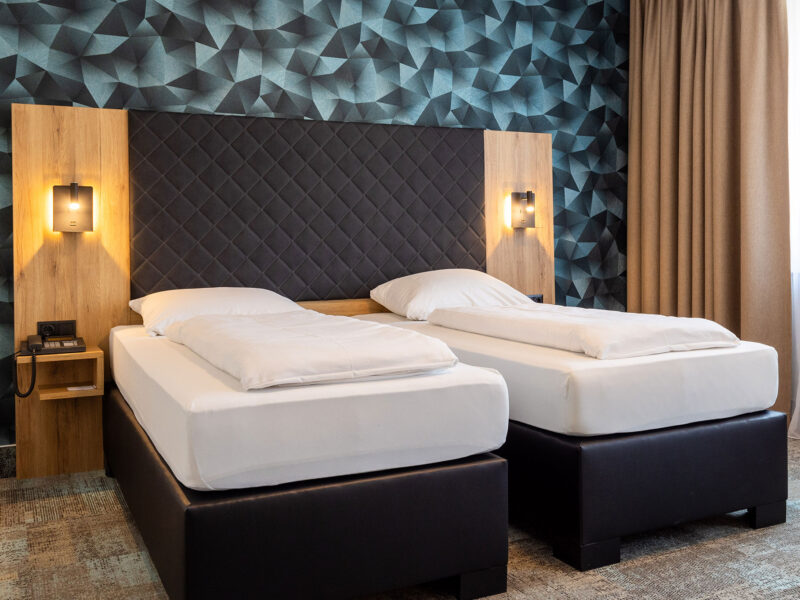 Modernes Doppel- oder Zweibettzimmer mit zwei Einzelbetten auf Teppichboden