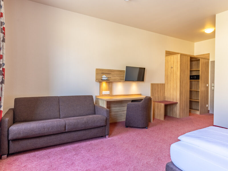 Twinzimmer mit Couch, Schreibtisch und Schrank