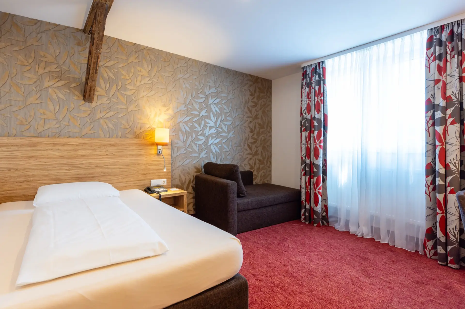 Einzelzimmer mit Sessel und großem Fenster im Hotel Lenz Fulda