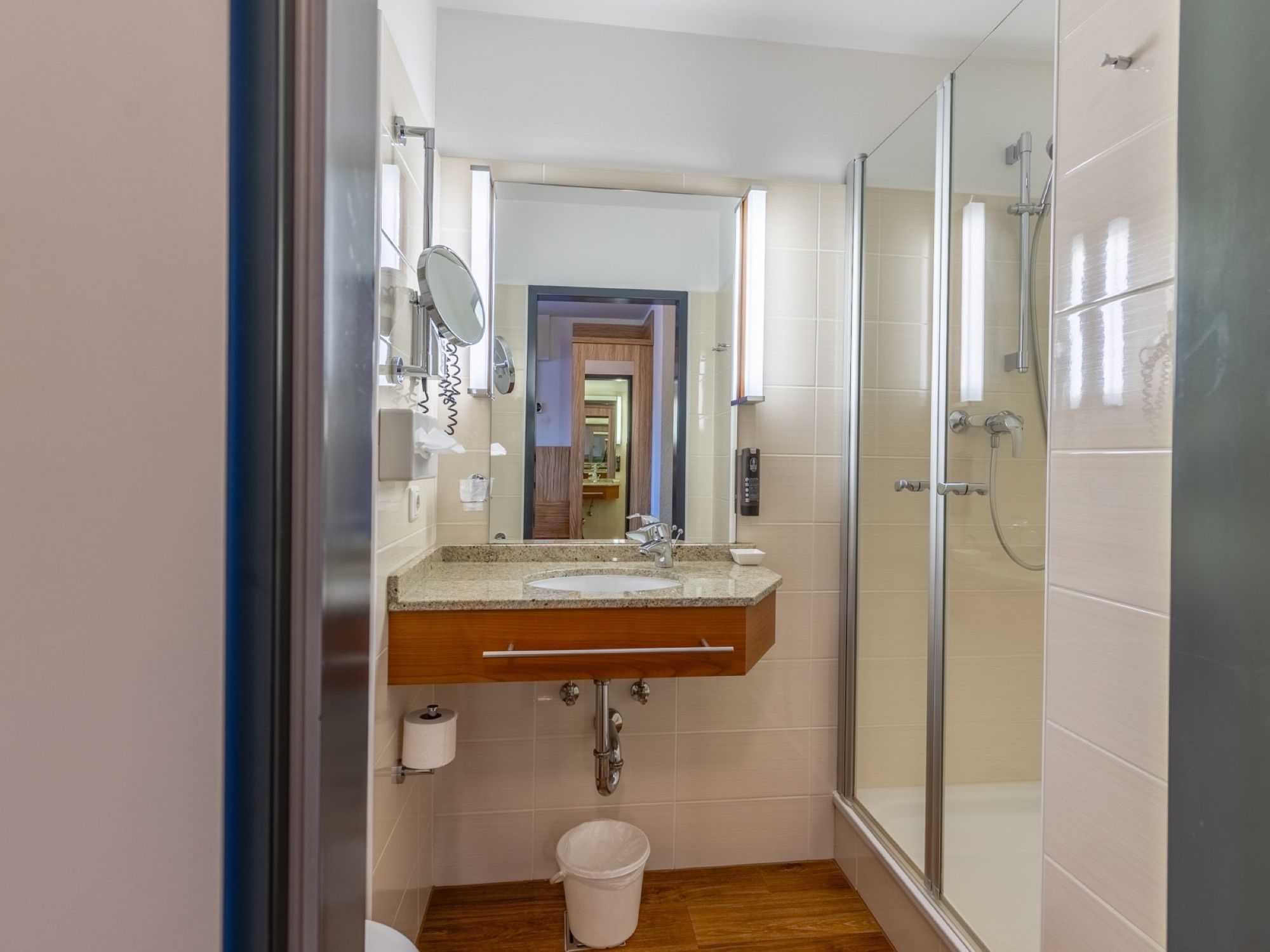 Bad mit Dusche und Waschtisch in einem Zimmer des Hotel Lenz